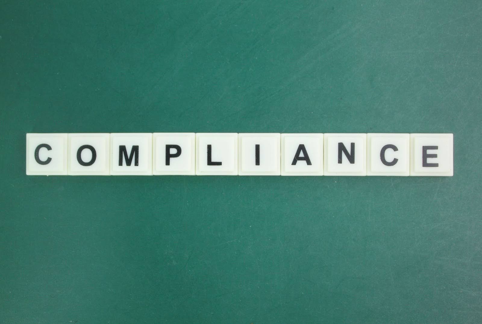 Word “compliance” on word tiles.