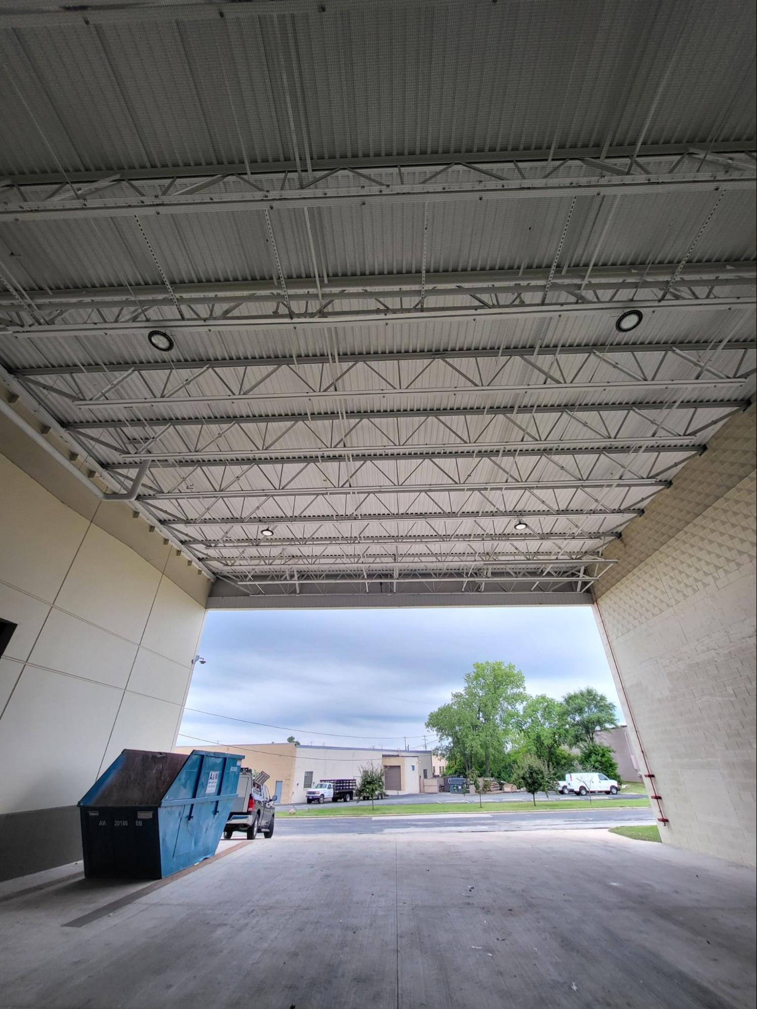 Ceiling bird netting protecting a hospital service entrance with a dumpster